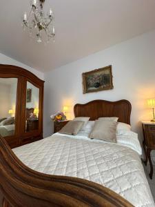 een slaapkamer met een groot bed met een kroonluchter bij GoldClass Apartament in Katowice