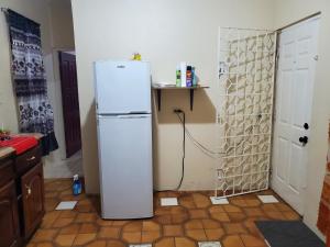 una nevera blanca en una cocina junto a una puerta en Nature's best, en Montego Bay