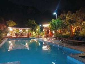 a swimming pool at night with a restaurant at Catba Papillon Garden Bungalows & Resort in Cat Ba