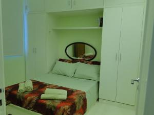 Dormitorio pequeño con cama y espejo en Apartamento Leblon Soleil, en Río de Janeiro