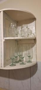a shelf with wine glasses and jars on it at Casa Estratégica in Sucre