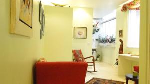 sala de estar con silla roja y paredes amarillas en Apartamento Leblon Soleil, en Río de Janeiro