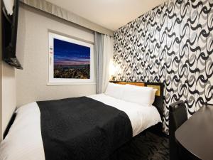 a hotel room with a bed and a window at APA Hotel & Resort Osaka Namba Ekimae Tower in Osaka