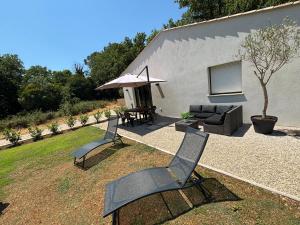 a patio with two chairs and a table and an umbrella at Les gîtes de Sandrella in Mouans-Sartoux