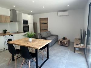a kitchen and living room with a wooden table and chairs at Les gîtes de Sandrella in Mouans-Sartoux +6 photos