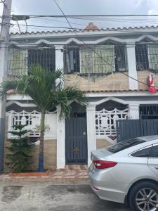 a house with a car parked in front of it at Recidencial sharael house in San Isidro