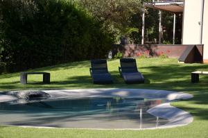 2 sillas y una piscina en un patio en B&B Dodici Lune, en Andora