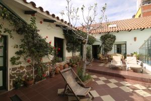 an outdoor patio with chairs and potted plants at Casa Verde B&B in Sucre