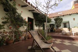 a wooden chair sitting on the patio of a house at Casa Verde Hostal in Sucre