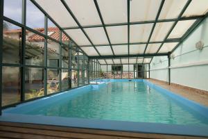 una piscina cubierta en un edificio con ventanas de cristal en Casa Verde B&B, en Sucre