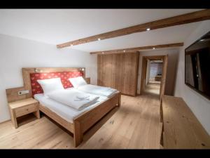 1 dormitorio con 1 cama y TV en Appartements Pöllhof, en Kitzbühel
