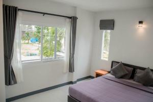 a bedroom with a bed and a large window at Nangkam Boutique House  +3 photos