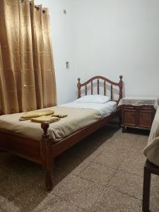 a bed with a wooden frame and curtains in a room at Hospedaje J Y K in La Rioja