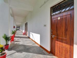a hallway with a wooden door in a building at Super Hotel O Madhuraj Palace Takrohi Road in Chinhat