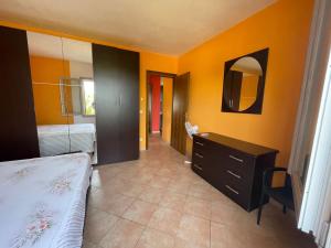 Un dormitorio con una cama, una cómoda y un espejo. en Casa Rosanna, en Lu Lioni