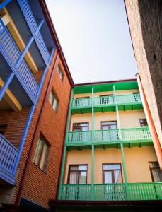 a green building with a blue roof and a blue door at Hotel Marlyn in Tbilisi City
