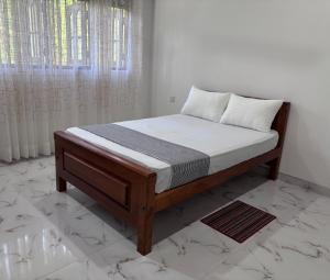 ein Bett in einem Schlafzimmer mit einer weißen Wand in der Unterkunft coco haven in Habaraduwa Central + 14 Fotos