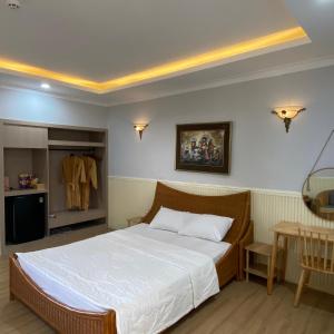 a bedroom with a large bed and a table at Hòn Cau Resort & Restaurant in Tuy Phong
