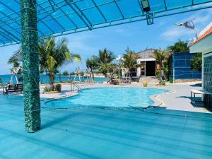 a swimming pool with the ocean in the background at Hòn Cau Resort & Restaurant in Tuy Phong