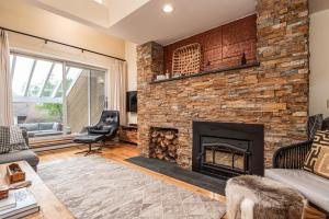 a living room with a brick fireplace at Club Sugarbush #8 condo in Warren