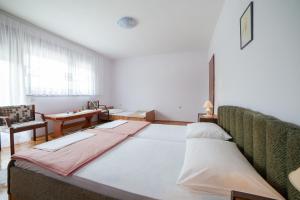 a large bed in a room with a table at Guest House Hodak in Rakovica