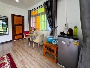 a kitchen with a refrigerator and a table with chairs at Nansilarom in Pua