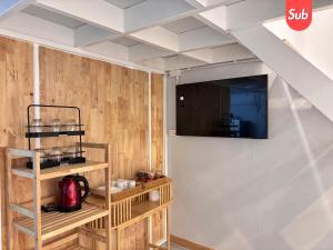 a room with wooden walls and a tv on a wall at Loft & Cozy Stay near Lee Garden in Hat Yai