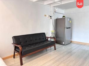 a black couch in a room with a refrigerator at Loft & Cozy Stay near Lee Garden in Hat Yai