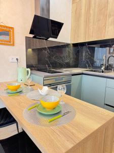 a kitchen with a table with bowls and glasses on it at Atmosfera Sea View Apartments in Odesa