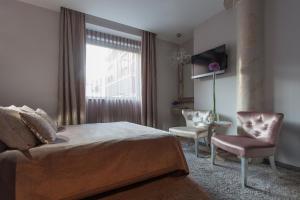 ein Schlafzimmer mit einem Bett, einem Stuhl und einem Fenster in der Unterkunft Soleil Boutique H in Sopot