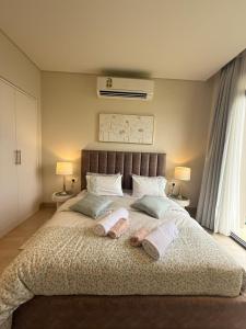 a bedroom with a large bed with towels on it at Ocean Breeze Hawana in Salalah