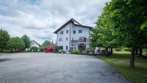 a large white house with a tree in front of it at Guest House Hodak in Rakovica