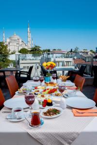 a table with plates of food on a table on a balcony at Ferman Hotel Old City -Special Category in Istanbul
