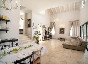 una sala de estar con una mesa y un sofá en לה פטלונה - ווילה מהממת עם בריכה פרטית מחוממת ומקורה בכפר ורדים, en Kefar Weradim