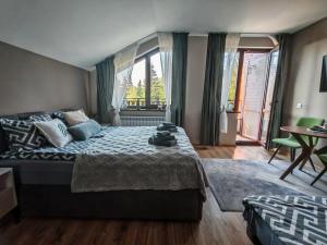 una camera da letto con un letto e una grande finestra di Mountain studio ASP E63 Borovets Gardens a Borovets