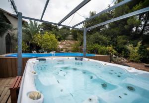 bañera de hidromasaje en una terraza con pérgola en לה פטלונה - ווילה מהממת עם בריכה פרטית מחוממת ומקורה בכפר ורדים, en Kefar Weradim