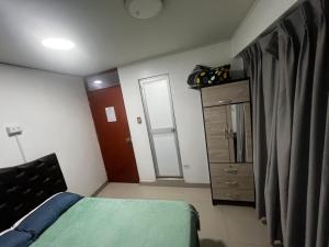 a small bedroom with a bed and a dresser at Huamanga plaza in Ayacucho