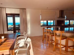 a kitchen and dining room with a table and chairs at Quill Cottage in Mossel Bay