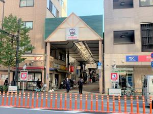 a man walking down a street in front of a building at 台東区 駅から徒歩3分施設a4f in Tokyo