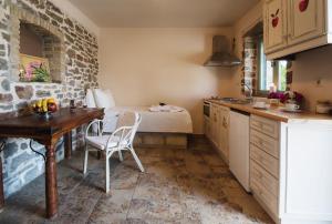 a kitchen with a table and a bed in a room at Palaeopoli Villas in Avlemonas