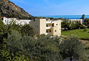 a building on a hill with the ocean in the background at Aretousa in Sougia