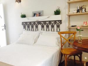 um quarto com uma cama branca, uma mesa e uma cadeira em Marè Rooms Bari old town center em Bari