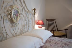 ピティリアーノにあるAppartamenti del Ceccottinoのベッドルーム(白いベッド1台、椅子付)
