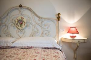 ピティリアーノにあるAppartamenti del Ceccottinoのベッド(白いヘッドボード、ランプ付)