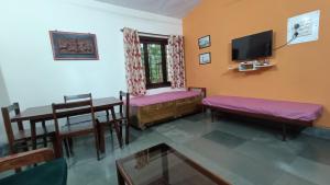 a living room with a table and chairs and a tv at Nivaant @ Vicharays in Alībāg