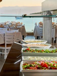 a buffet with many plates of food on a table at Nautica Bay Hotel in Porto Heli