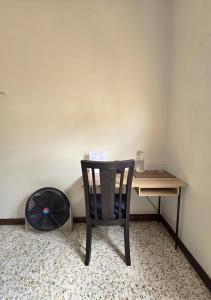 una sedia posta di fronte a una scrivania con un ventilatore di A 3 minutos del aeropuerto a Estación Pamplona