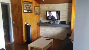 a living room with a television on a brick wall at appartement 2 pieces valberg in Valberg