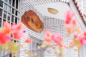 a white brick building with a sign on the wall at 峽谷民宿 Valley B&B in Fushi +5 photos