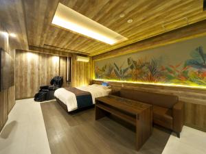 a bedroom with a bed and a bench and a painting at HOTEL BOTA 豊橋 -Adult Only- in Toyohashi